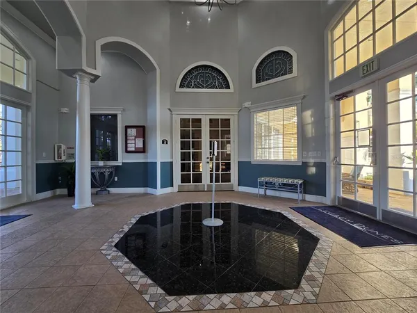 a view of a livingroom with furniture chandelier and windows