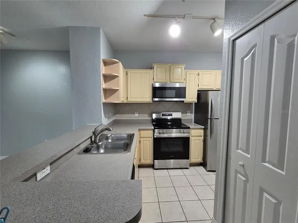 a kitchen with stainless steel appliances a refrigerator sink and stove