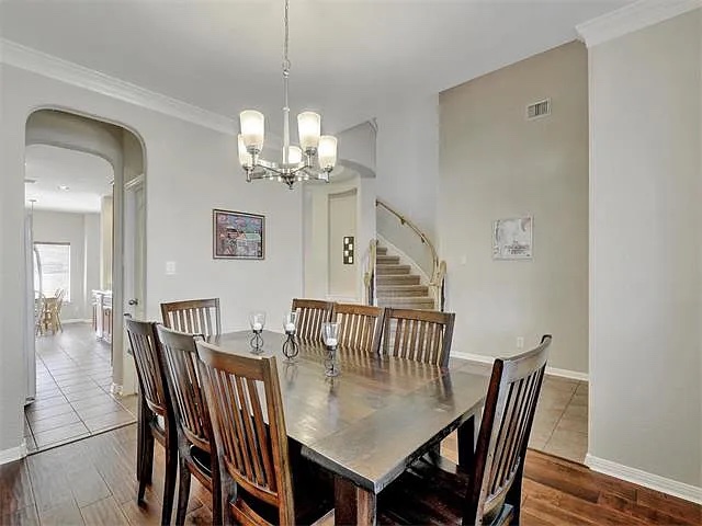 1832 Nelson Ranch Loop Cedar Park, TX 78613 - Photo 6 of 15 A well-appointed dining room features elegant wood flooring and a classic chandelier, offering a perfect setting for gatherings.