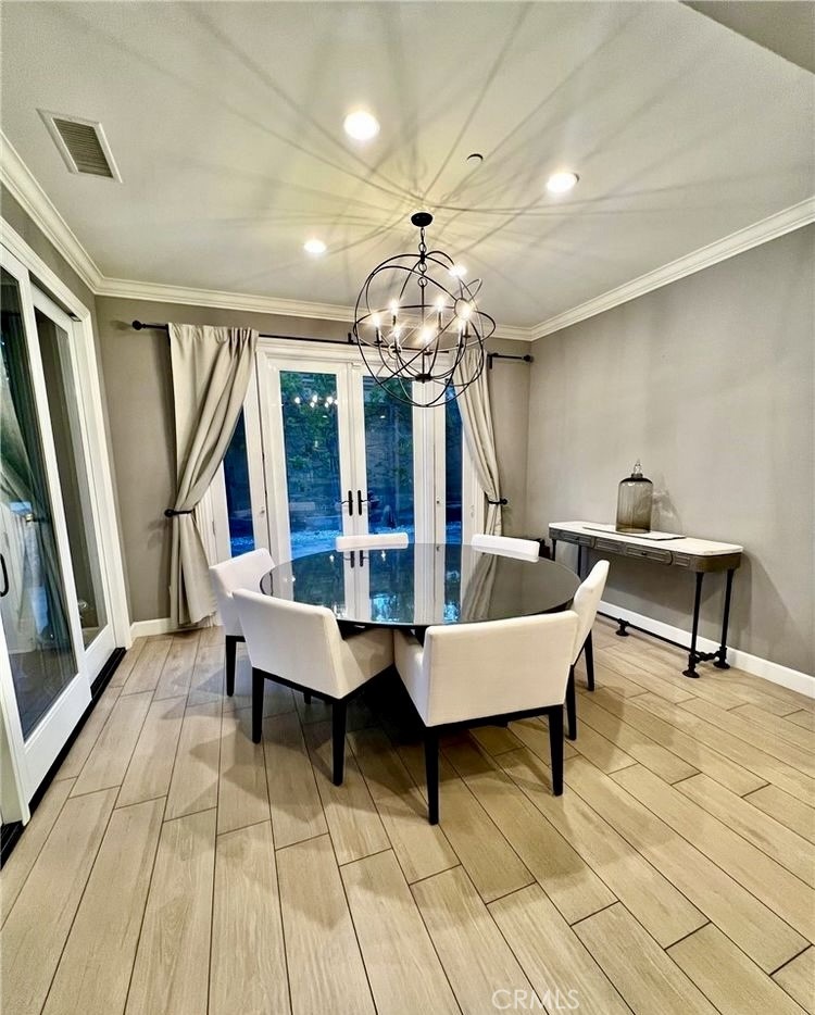 68 Chianti Irvine, CA 92618 - Photo 5 of 17 a living room with couches a fireplace and a dining table with wooden floor