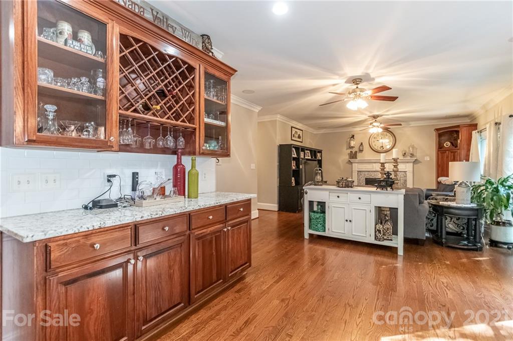 933 Ashford Way Fort Mill, SC 29708 - Photo 22 of 48 a kitchen with kitchen island granite countertop a sink cabinets and wooden floor