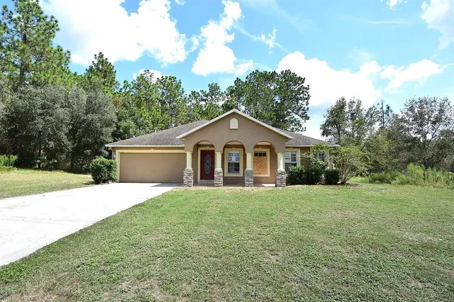 a front view of a house with yard and green space