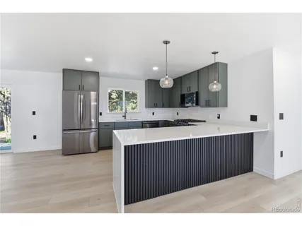 a kitchen with a sink a refrigerator and cabinets