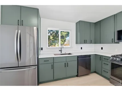 a kitchen with stainless steel appliances granite countertop a refrigerator sink and cabinets