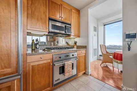 a kitchen with stainless steel appliances granite countertop a stove microwave and refrigerator