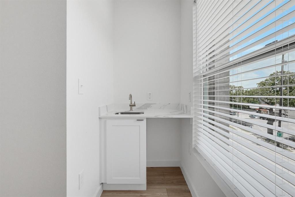 504 South O Connor Road Irving, TX 75060 - Photo 14 of 23 Single-basin sink with a gooseneck faucet, set within a white countertop and featuring a built-in cabinet with a shaker-style door