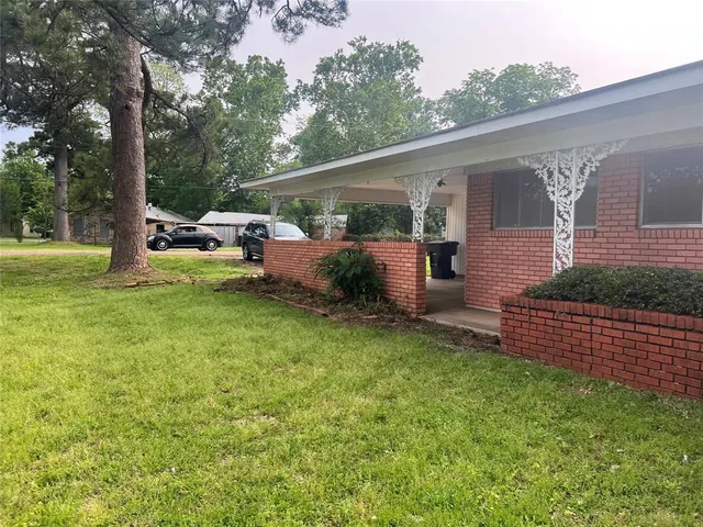 a view of a backyard with couches plants and large tree