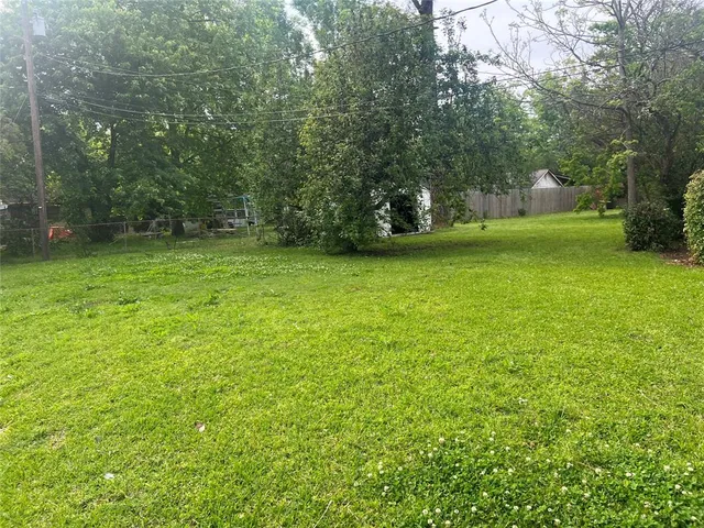 a view of a field of grass and trees