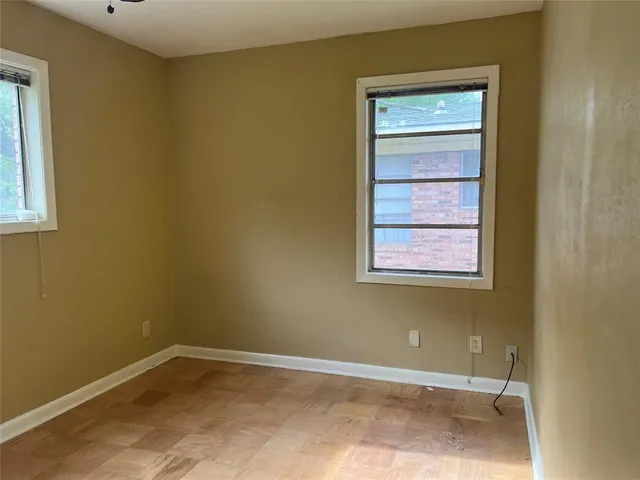 a view of a small space with wooden floor and a window