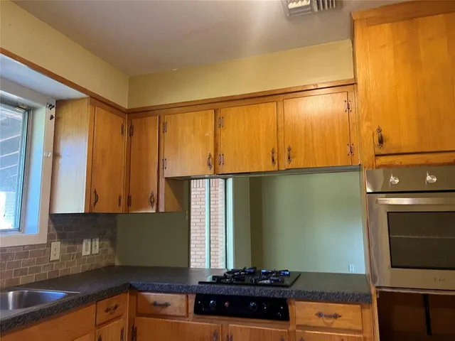 a kitchen with a sink a stove and cabinets