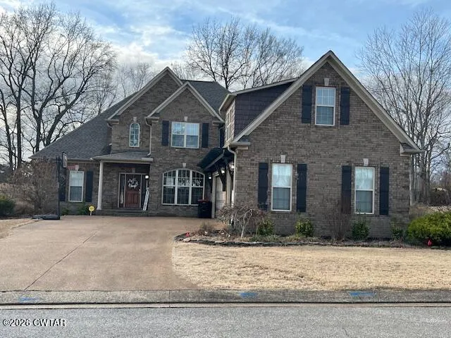 a front view of house with yard and trees around