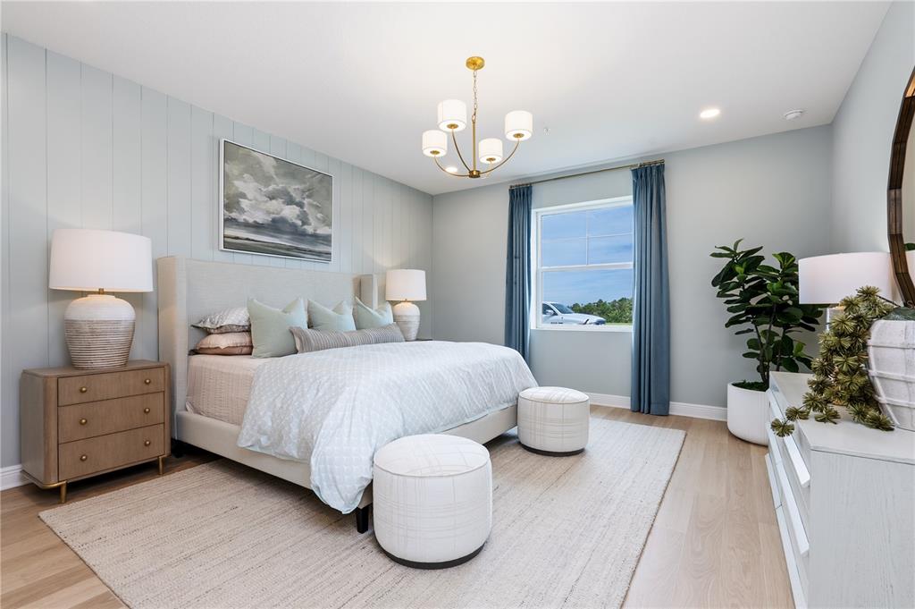 17841 Broadleaf Loop Venice, FL 34293 - Photo 11 of 19 a spacious bedroom with a bed and a chandelier