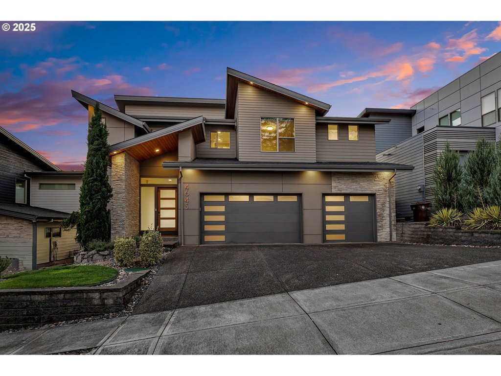 a front view of a house with yard and parking