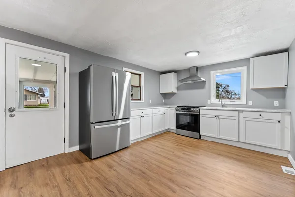 a kitchen with granite countertop a refrigerator and a stove top oven