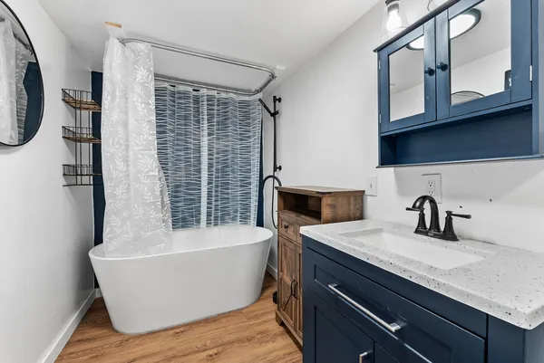 a bathroom with a granite countertop sink and a bathtub