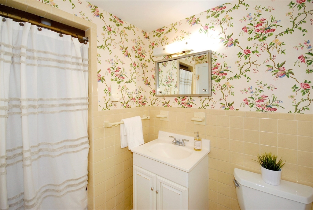 469 Hayward Mill Road Concord, MA 01742 - Photo 18 of 30 a bathroom with a sink and mirror with shower curtain