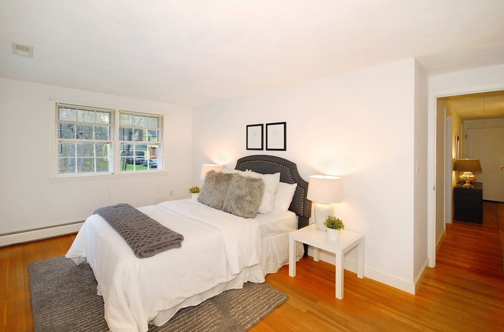 469 Hayward Mill Road Concord, MA 01742 - Photo 21 of 30 a bedroom with a bed and wooden floor