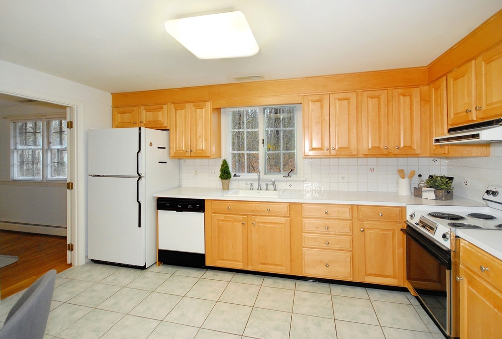 469 Hayward Mill Road Concord, MA 01742 - Photo 10 of 30 a kitchen with stainless steel appliances granite countertop a stove a sink and a refrigerator