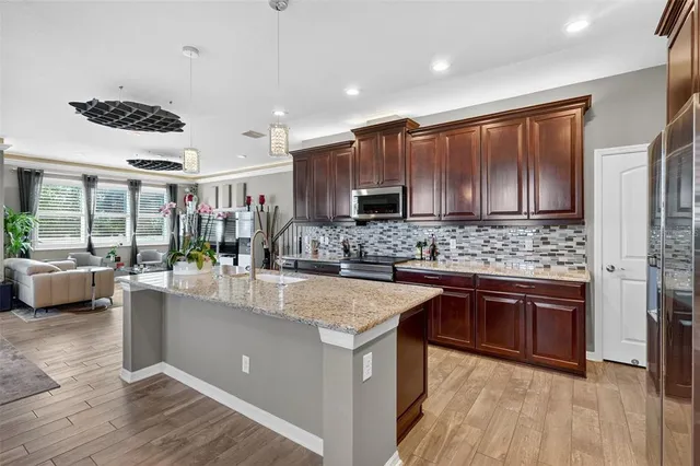 a kitchen with stainless steel appliances granite countertop a sink stove and refrigerator
