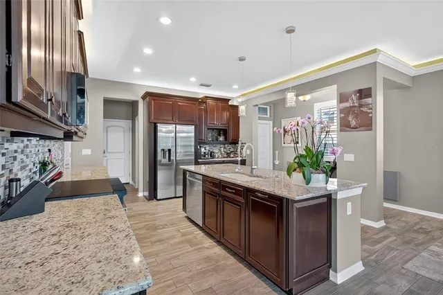 a kitchen with stainless steel appliances granite countertop a stove a sink and a refrigerator