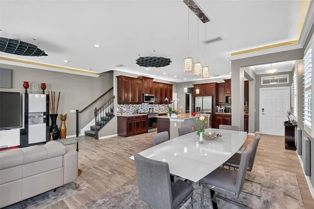 a dining hall with stainless steel appliances kitchen island granite countertop a dining table and chairs