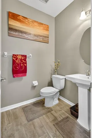 a bathroom with a toilet a sink and mirror