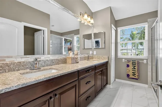 a bathroom with a granite countertop sink double vanity and a mirror