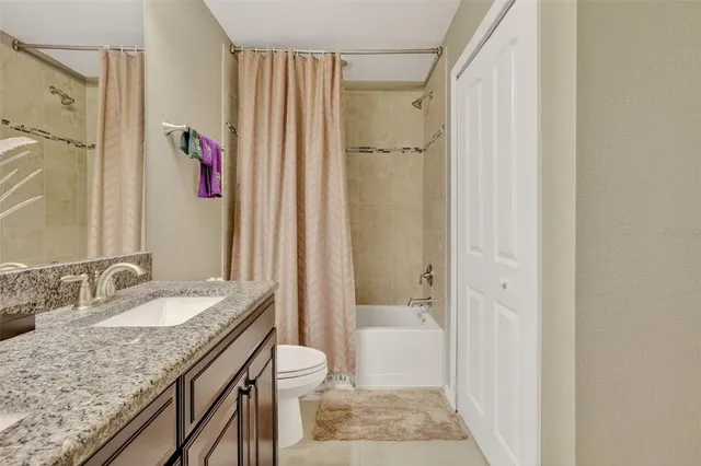 a bathroom with a granite countertop sink a mirror and a bathtub