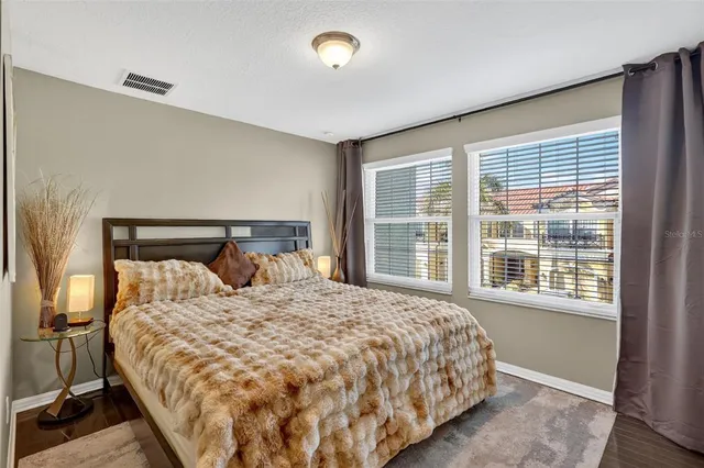 a large bed sitting in a bedroom next to a window