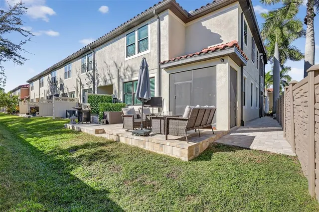 a view of a patio with couches table and chairs and potted plants
