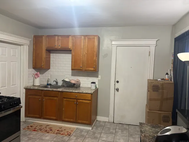 a kitchen with stainless steel appliances granite countertop a refrigerator and a stove top oven