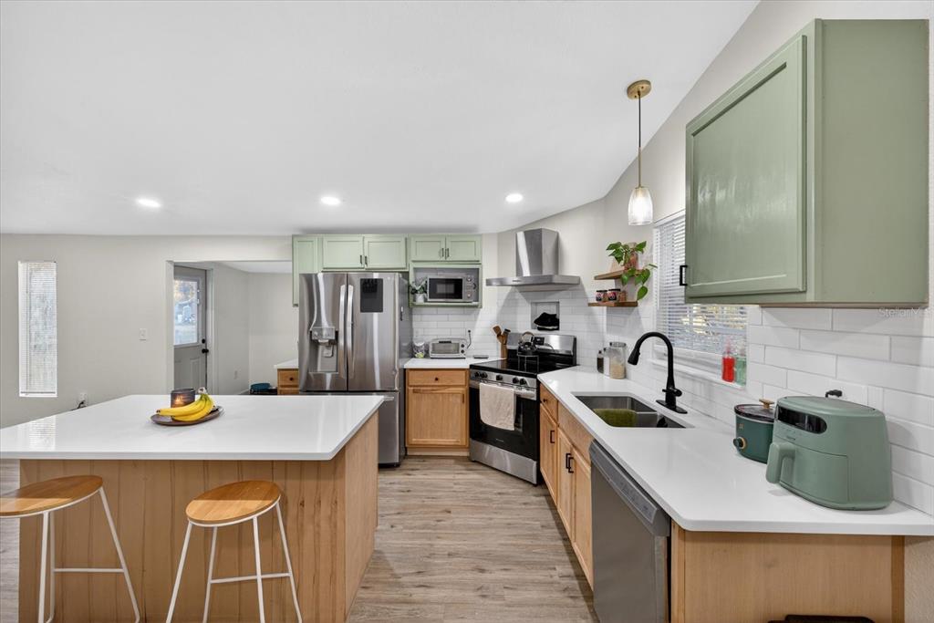 4233 Vinson Road Lakeland, FL 33810 - Photo 12 of 38 a kitchen with a sink a stove and chairs