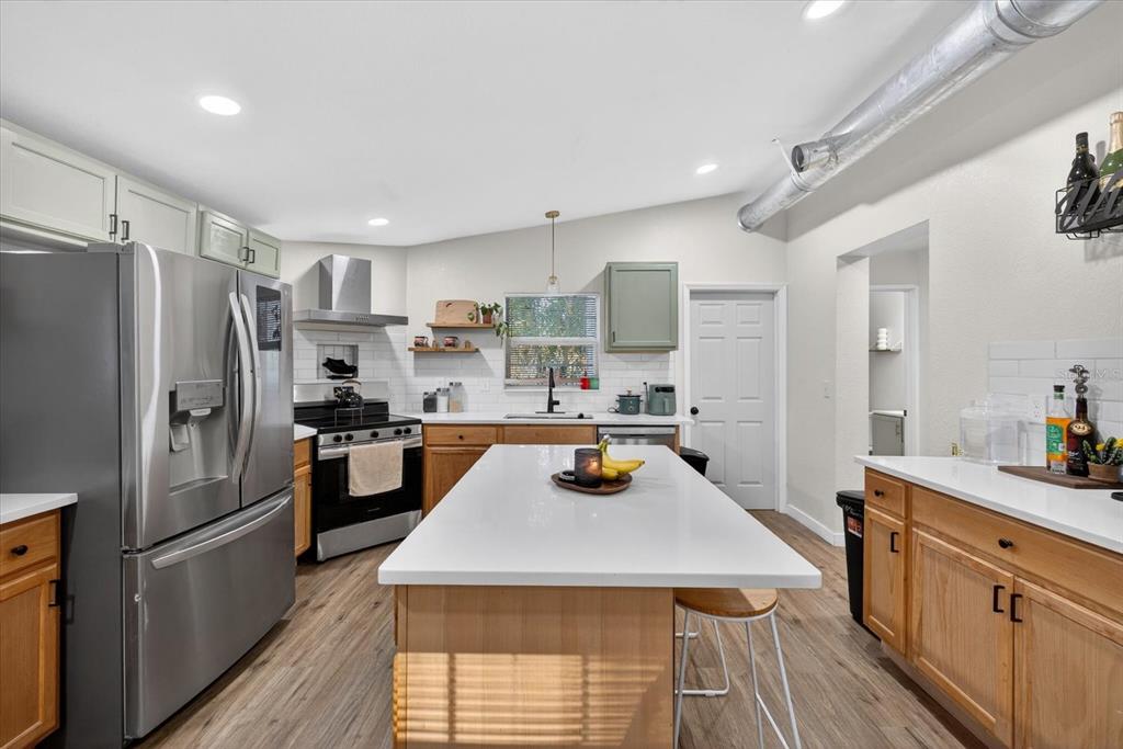4233 Vinson Road Lakeland, FL 33810 - Photo 10 of 38 a kitchen with stainless steel appliances a refrigerator a stove a sink dishwasher a oven with white cabinets and wooden floor