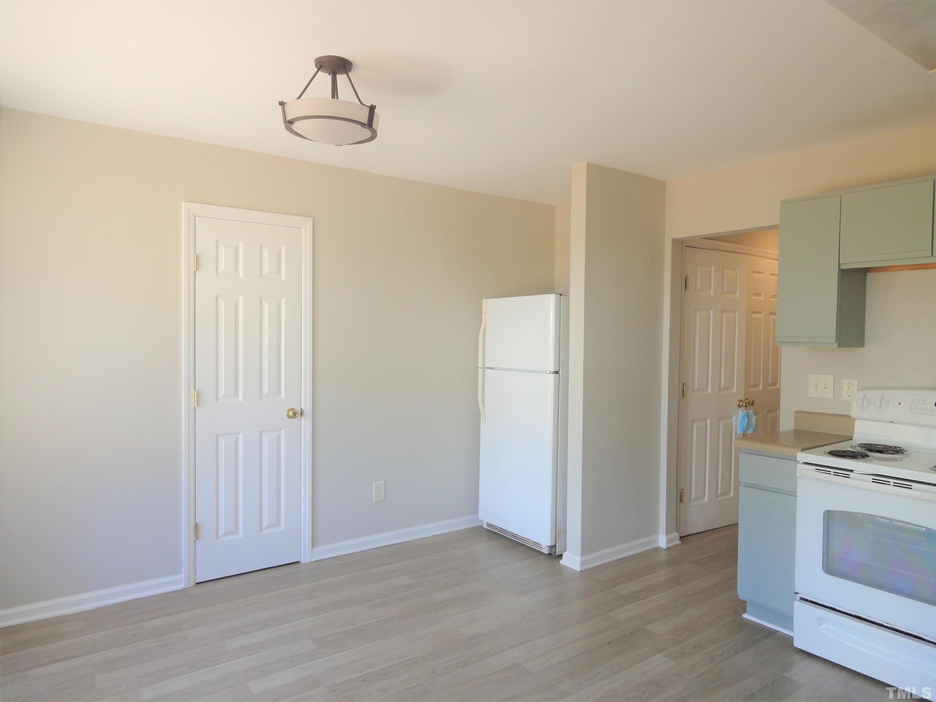 3615 Cyrus Street Raleigh, NC 27610 - Photo 13 of 36 a view of kitchen and empty room with wooden floor