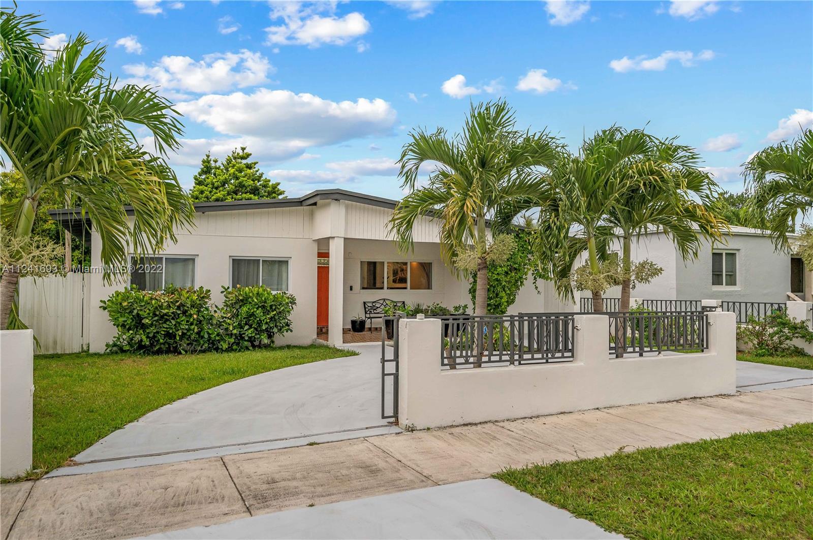 a front view of a house with a garden and plants