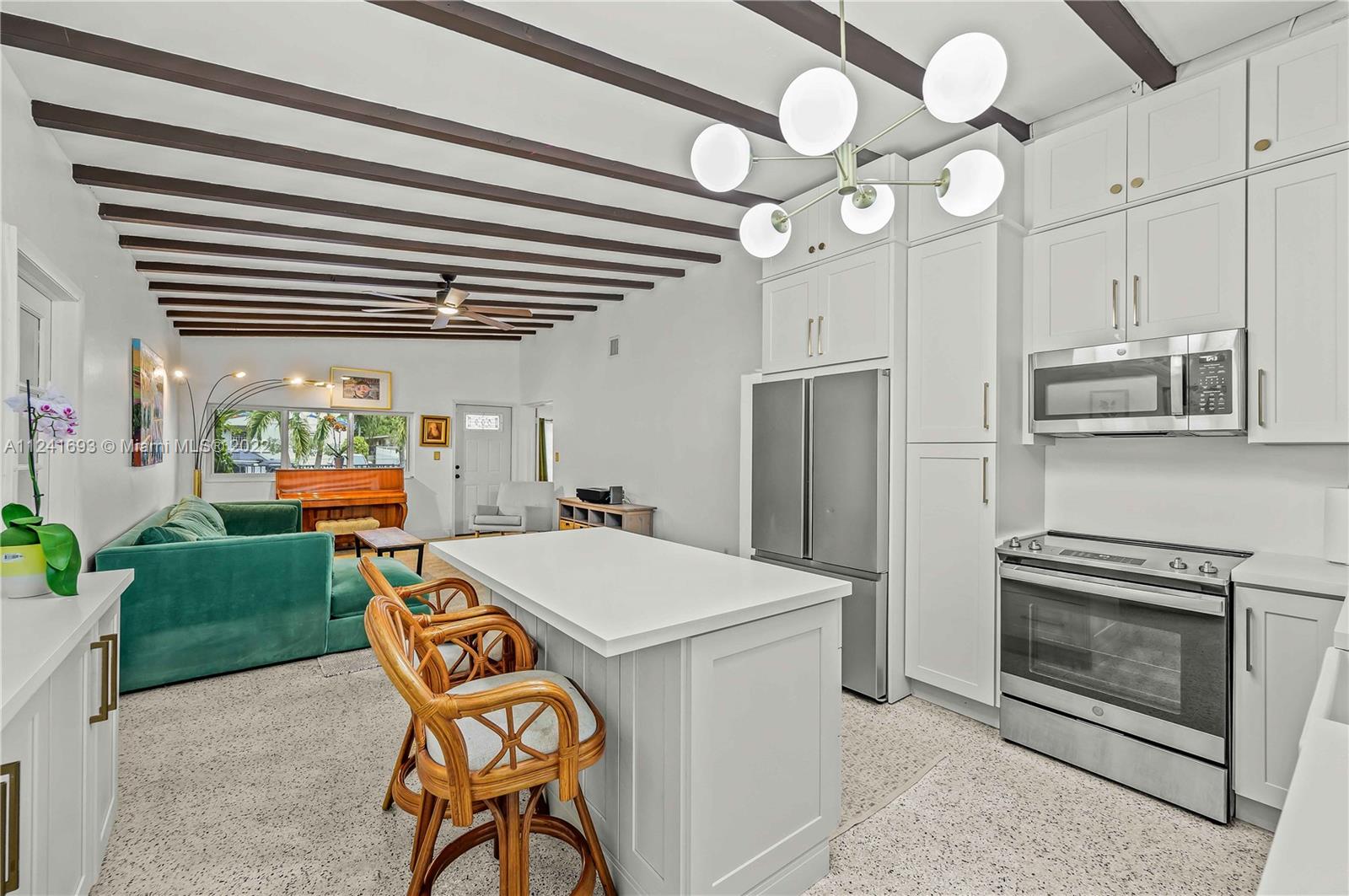 6730 Southwest 32nd Street Miami, FL 33155 - Photo 13 of 31 a kitchen with stainless steel appliances granite countertop a stove a sink dishwasher and a refrigerator with wooden floor