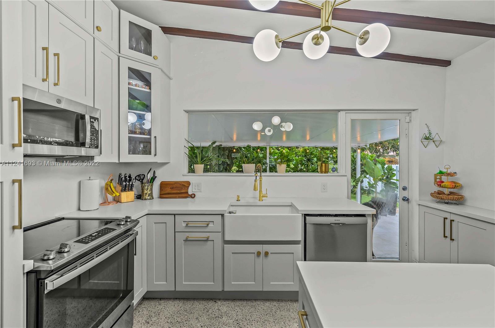 6730 Southwest 32nd Street Miami, FL 33155 - Photo 14 of 31 a kitchen with a sink a stove and cabinets