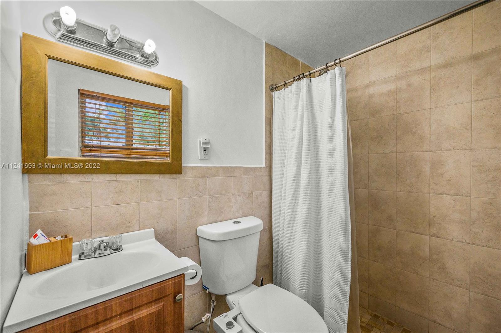 6730 Southwest 32nd Street Miami, FL 33155 - Photo 24 of 31 a white toilet sitting next to a bathroom sink