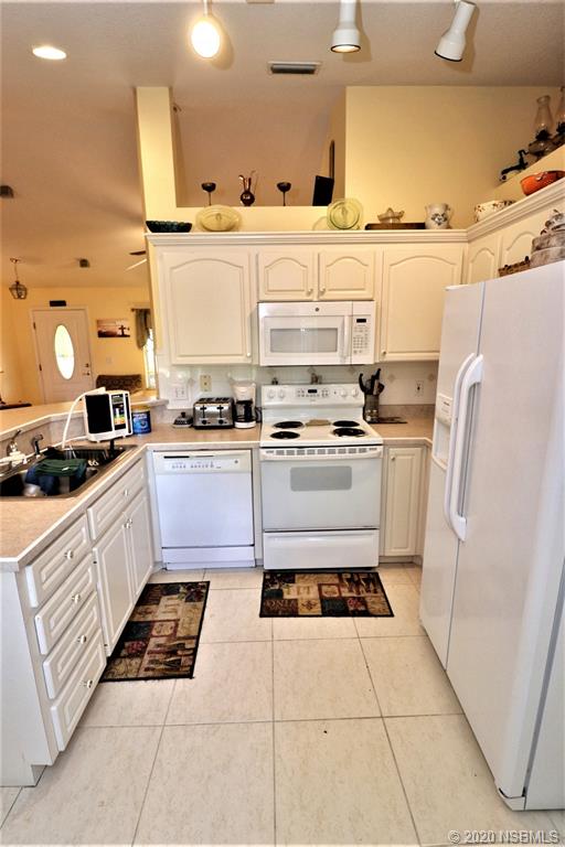 3316 Mango Tree Drive Edgewater, FL 32141 - Photo 11 of 28 a kitchen with stainless steel appliances granite countertop a sink and cabinets