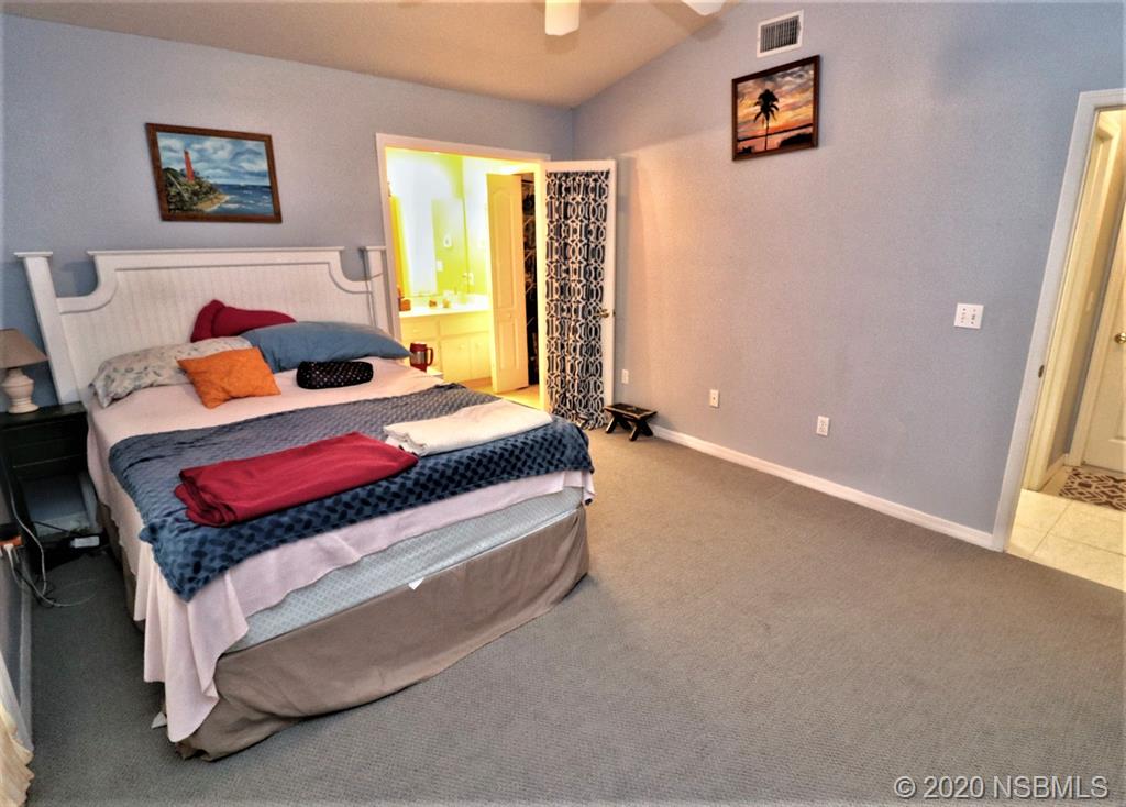 3316 Mango Tree Drive Edgewater, FL 32141 - Photo 12 of 28 a bedroom with a bed and a dresser next to a window