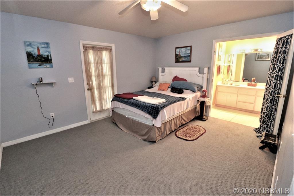 3316 Mango Tree Drive Edgewater, FL 32141 - Photo 13 of 28 a bedroom with a bed and a chandelier