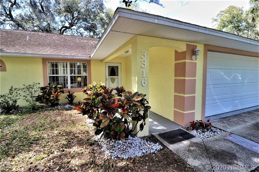 3316 Mango Tree Drive Edgewater, FL 32141 - Photo 5 of 28 a front view of a house with a garden