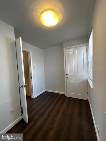 an empty room with wooden floor and a window