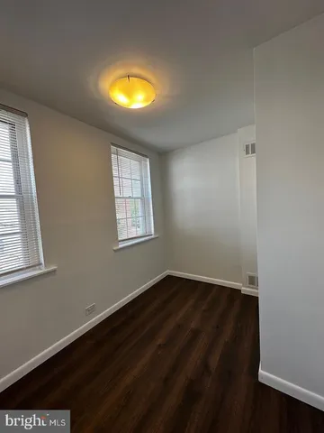 an empty room with a window and wooden floor