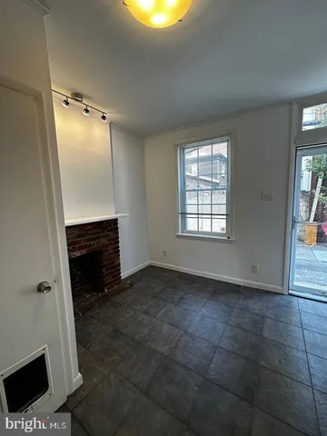 a view of an empty room with a fireplace and a window