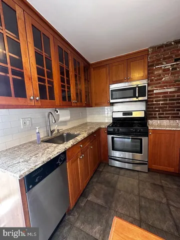a kitchen with a stove sink and cabinets
