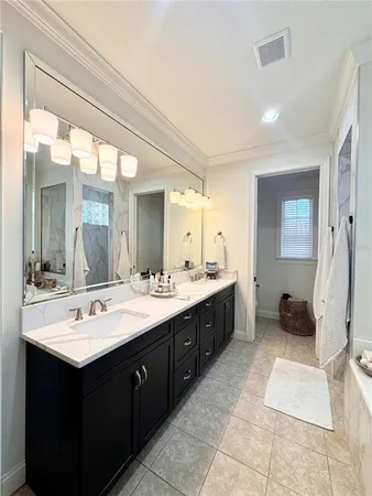 a bathroom with a double vanity sink a mirror and a bathtub