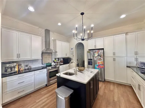 a kitchen with stainless steel appliances kitchen island granite countertop a sink and cabinets