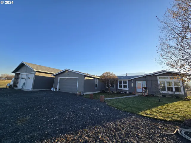 a view of a house with a yard and large trees