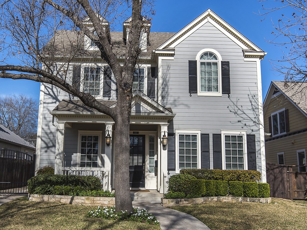 a view of a white house with large windows and a tree in front of it